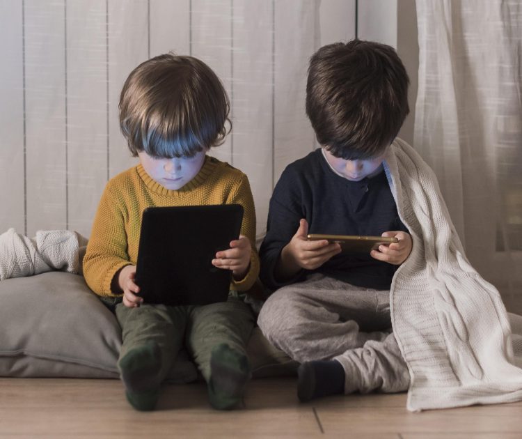 full-shot-kids-sitting-with-devices