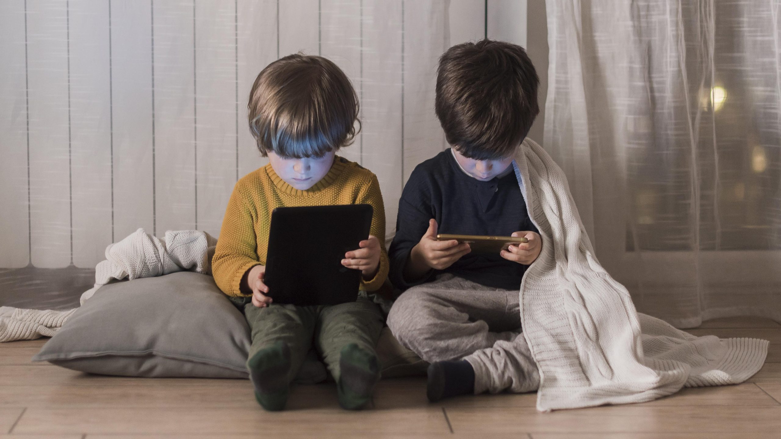 full-shot-kids-sitting-with-devices